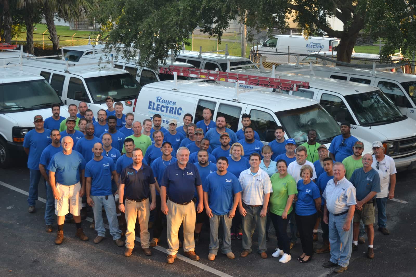 The Rayco Electric team standing together in front of their fleet of service vans in Bradenton, Florida